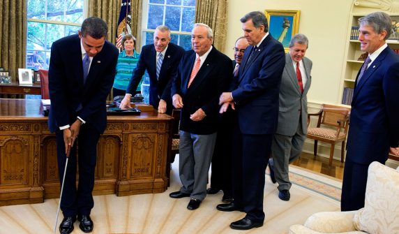 Barack Obama takes a practice putt in the Oval Office 1